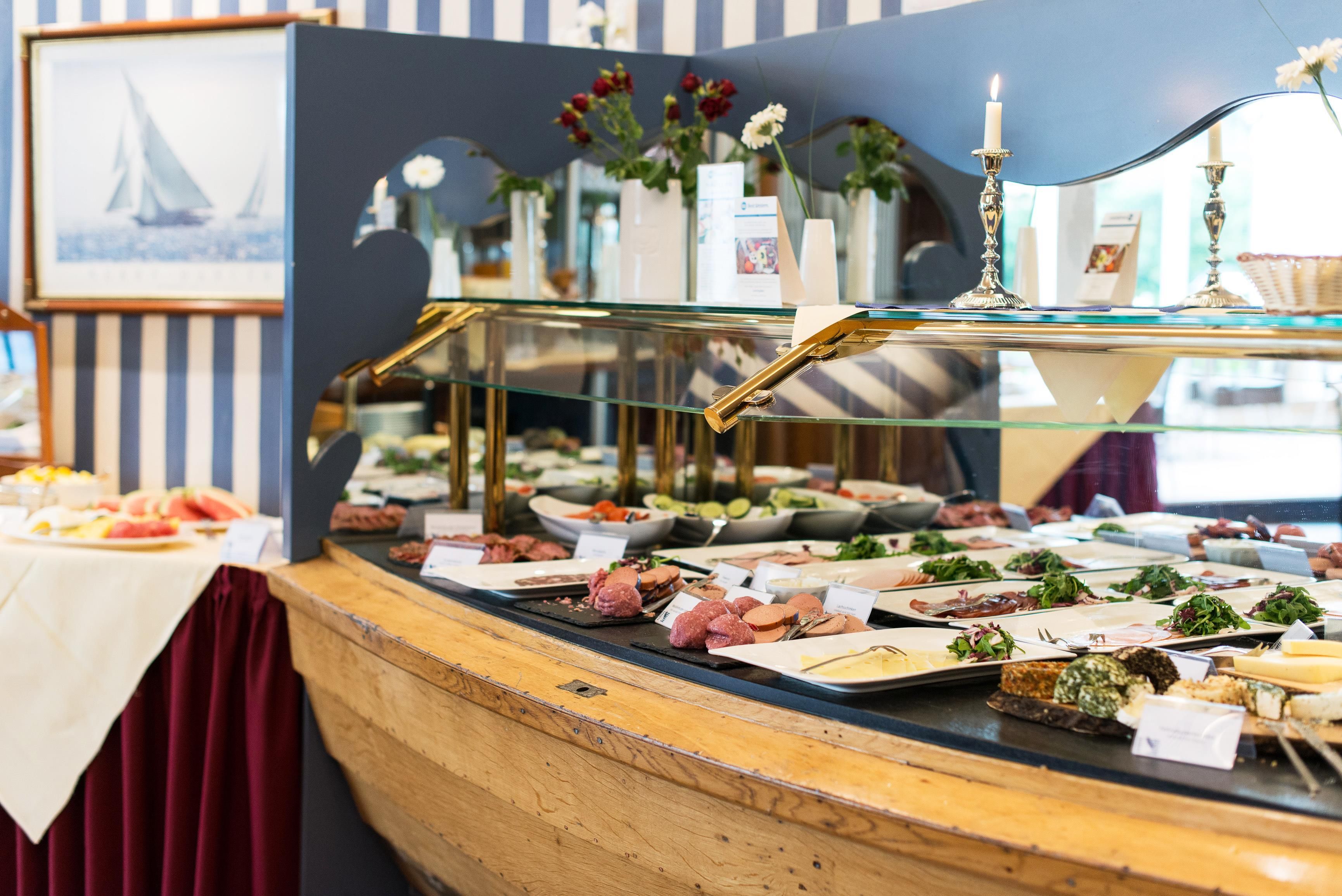 A buffet with various food items and a decorative mirror.