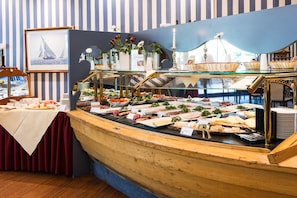 A buffet setup with various food items and a decorative mirror. - Seehotel Frankenhorst - BW Signature Collection (Schwerin)