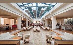 A spacious lobby with a high ceiling, a central bar area, and seating arrangements. - Alkyon Resort Hotel & Spa (Velo-Vocha)