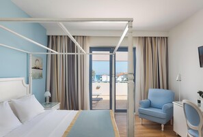 A hotel room with a bed, a desk, a chair, and a balcony with a view. - Alkyon Resort Hotel & Spa (Velo-Vocha)