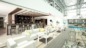 A modern indoor pool area with a bar, white sofas, and a wooden deck.