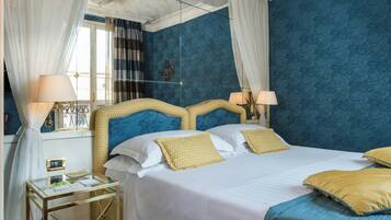 A hotel room with a bed, bedside tables, and curtains.