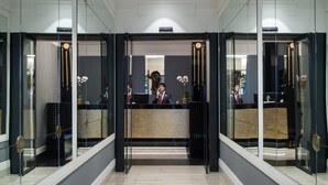 Een moderne receptie met glazen deuren, een receptiebalie en een potorkidee.