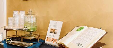 A reception desk with a glass container, a menu, and a framed artwork on the wall.