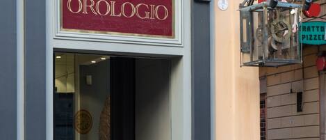 Une devanture de magasin avec une enseigne indiquant « ALBERGO OROLOGIO ».