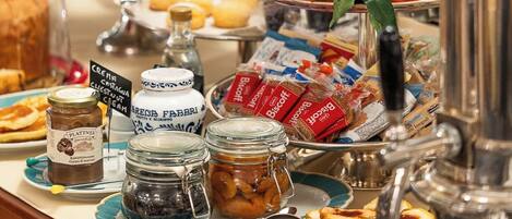 Una mesa de buffet con diversas opciones de comida, incluyendo frutas, pasteles y salsas.