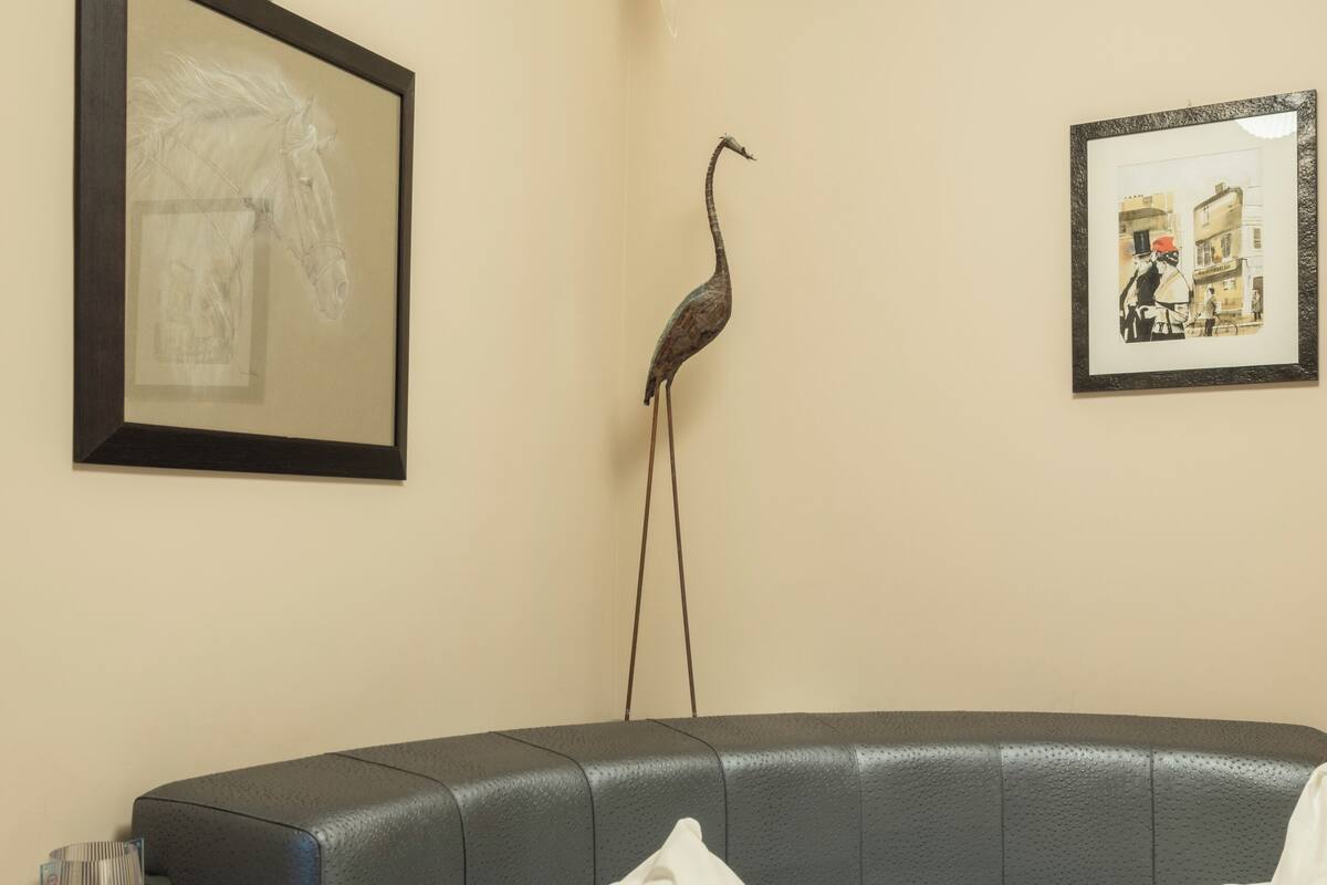 Une chambre à coucher avec un lit, une table de chevet, une lampe et deux tableaux encadrés accrochés au mur.