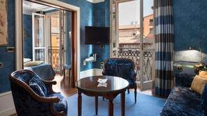 Een kamer met een blauwe wand, een bed, een televisie, een tafel en een bank.