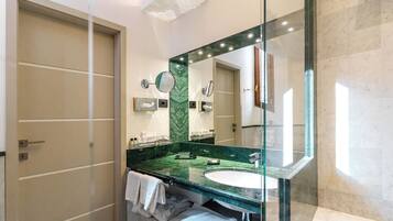Een moderne badkamer met een grote spiegel, een groen marmeren aanrechtblad en een witte wastafel.