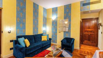 A living room with a blue sofa, a wooden coffee table, and a blue armchair.