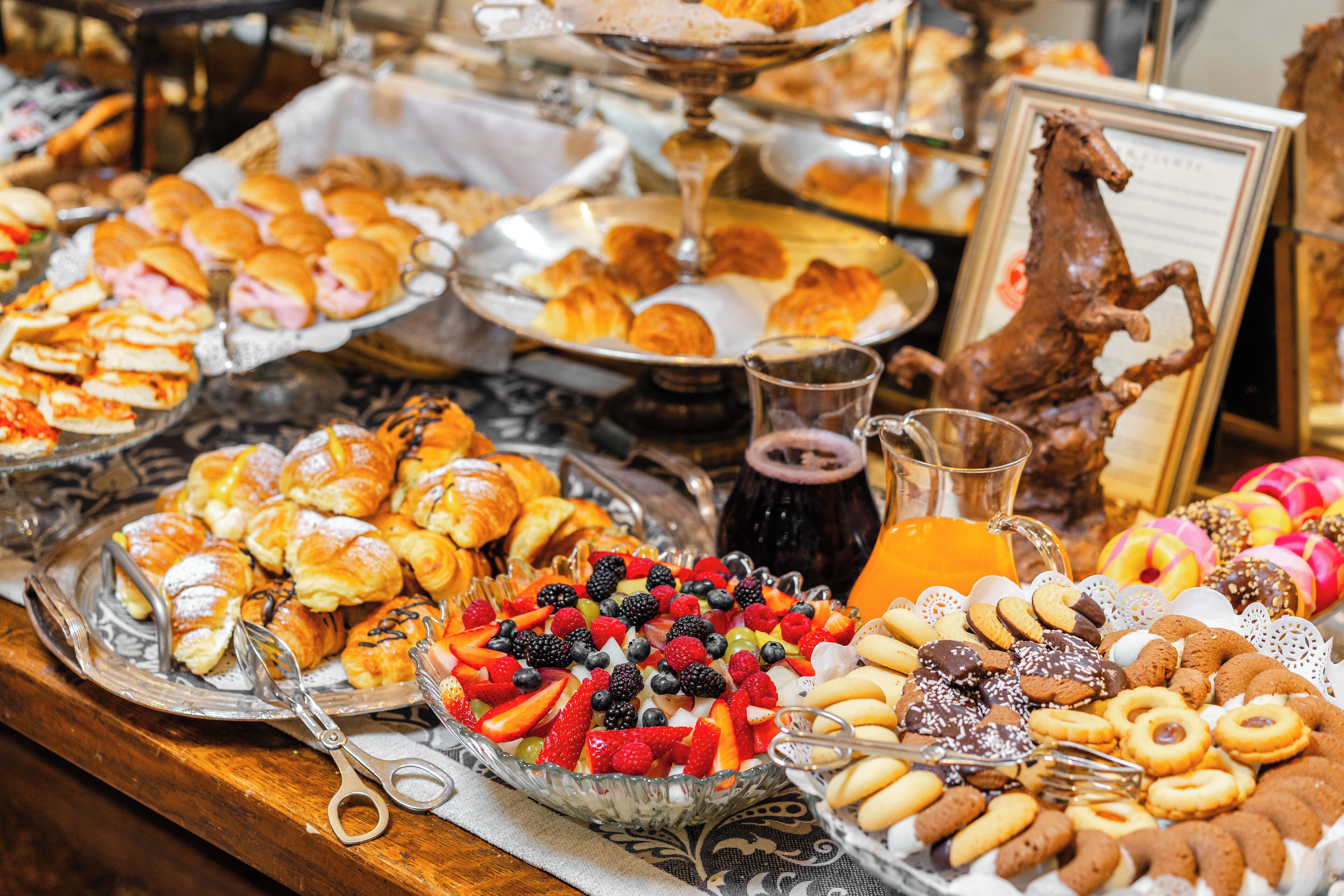 Un buffet con diversi dolci, frutta e bevande.