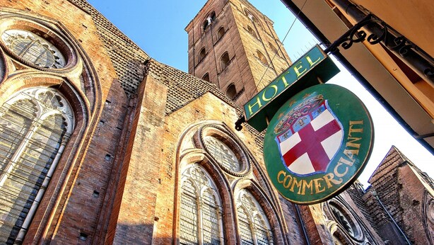 Une enseigne d’hôtel avec des armoiries et le mot « HÔTEL » écrit au-dessus.