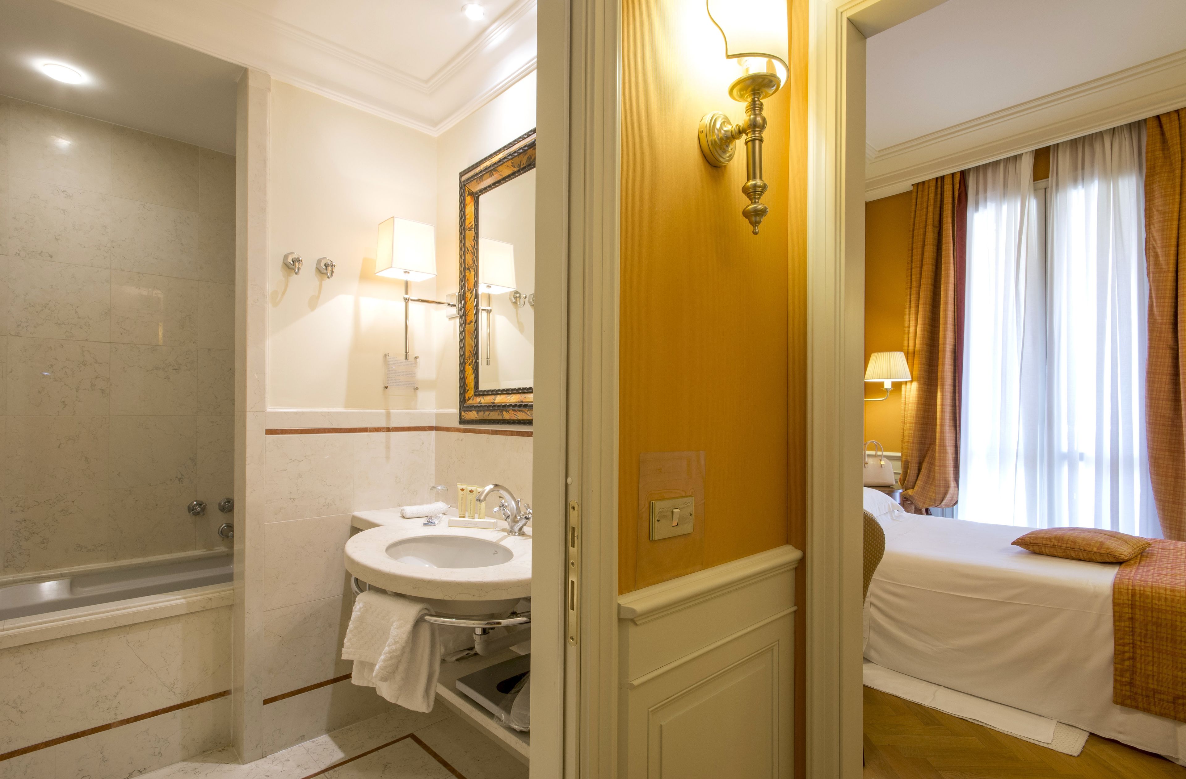 A bathroom with a bathtub, sink, and mirror.