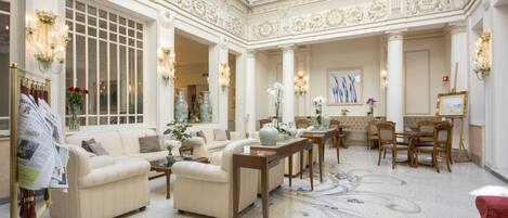 A spacious interior with a high ceiling, large windows, and ornate wall decorations.