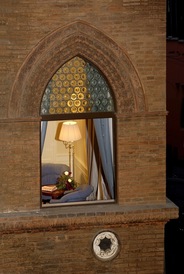 A brick fireplace with a decorative arch and a circular window. - Hotel Corona d'Oro (Bologna)