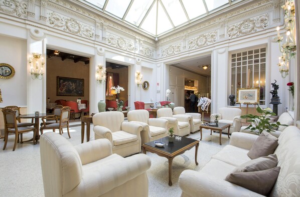 Experience the elegant lobby with plush seating, a coffee table, and tasteful wall decorations.
