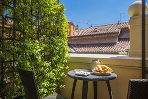 Enjoy an outdoor dining experience with a view of the traditional tiled roof building from this balcony.