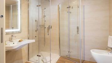 Ein modernes Badezimmer mit einer Duschkabine, einem Waschbecken und einem Spiegel.
