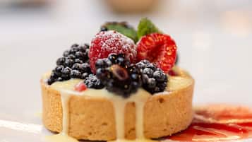 Postre amb nabes i nata sobre un plat blanc.