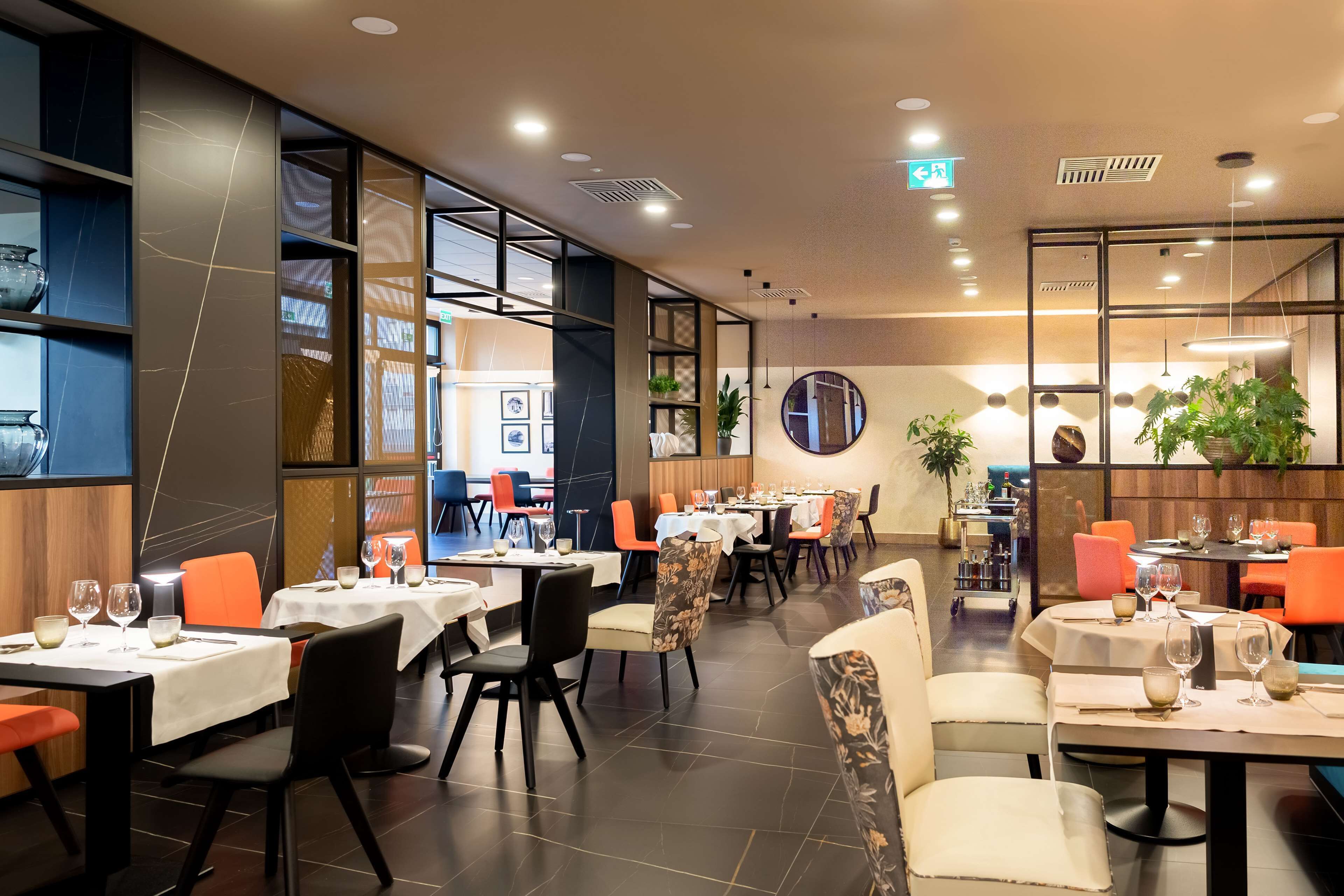 Un restaurante moderno con varias áreas de comedor, cada una con mesas y sillas.