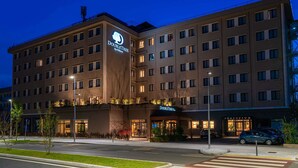 A multi-story hotel with a prominent "DoubleTree by Hilton" sign, a well-lit entrance, and a parking area. - DoubleTree by Hilton Brescia (Brescia)