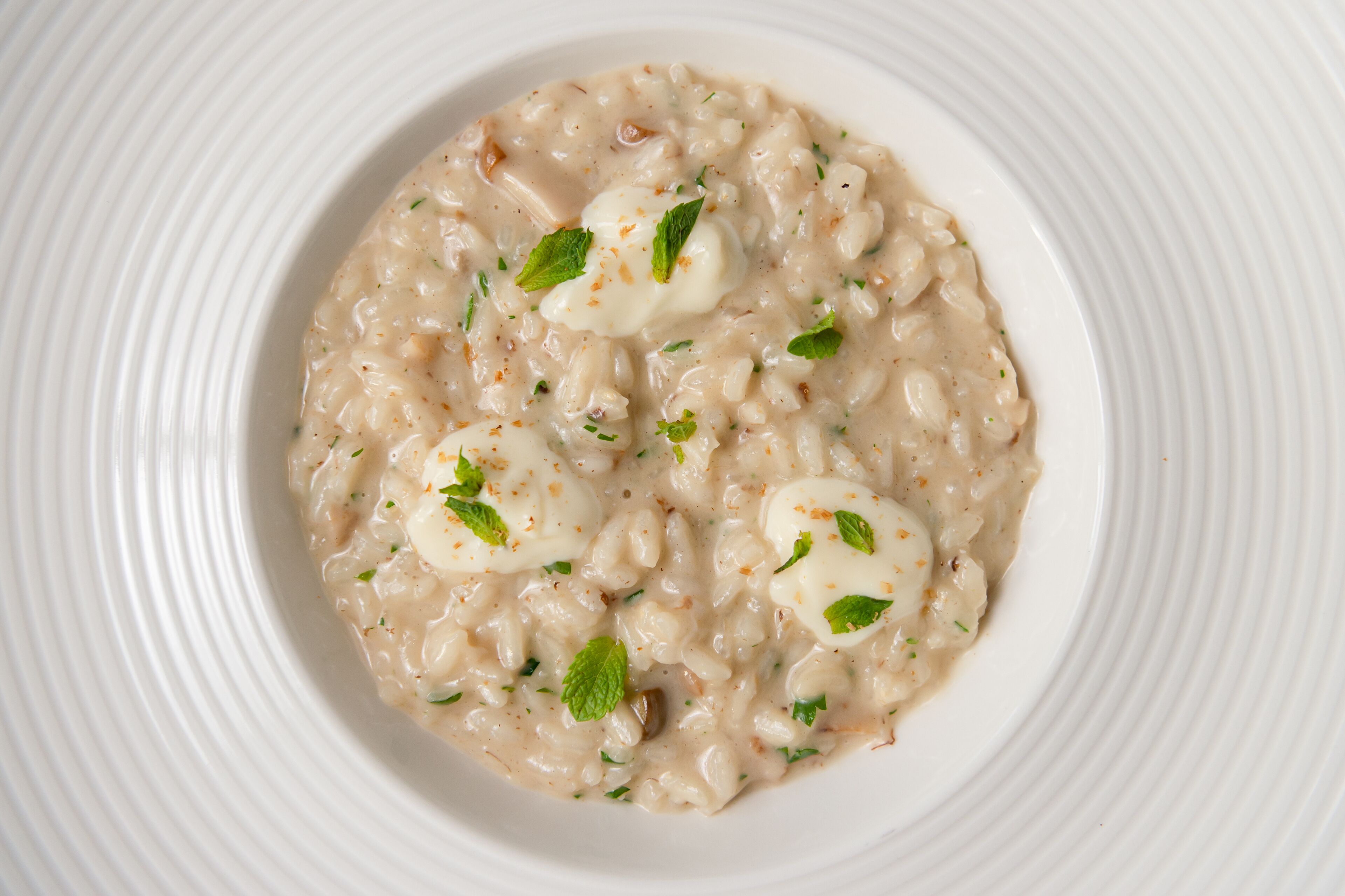 Een kom romige risotto met garnering.
