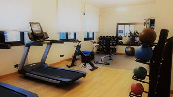 A gym with treadmills, exercise bikes, and various weights.