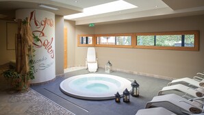 Zona de spa con hidromasaje, sillas de descanso y una pared con el texto "Agua Solis".