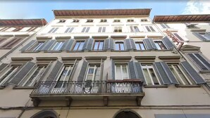 A multi-story building with a balcony and a sign that reads "Hotel". - BYPILLOW Goldoni (Florence)