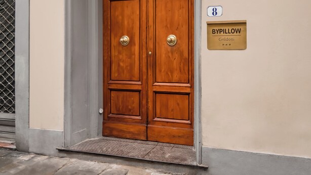 A wooden double door with a sign above it reading "BYPillow Goldoni". - BYPILLOW Goldoni (Florence)