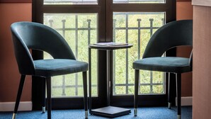 A room with a large window, two chairs, a small table, and a notebook on the floor. - BYPILLOW Goldoni (Florence)