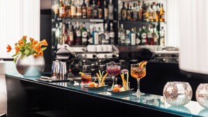 Un bar con diversas bebidas y botellas al fondo.
