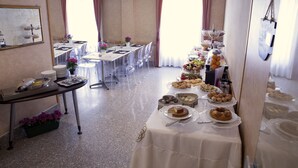 Ein Essbereich mit gedeckten Tischen, ein Buffet mit verschiedenen Speisen und ein Spiegel an der Wand.
