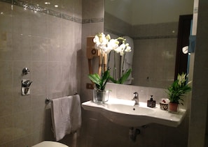 Deep soaking tub, rainfall showerhead, slippers, towels