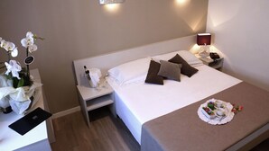 Ein ordentlich bezogenes Bett mit Kissen, ein Nachttisch mit Lampe und ein Tablett mit Speisen und Getränken.
