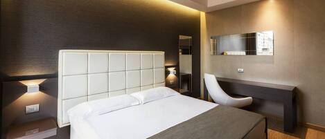 Une chambre d’hôtel moderne avec un grand lit, un bureau et une chaise.