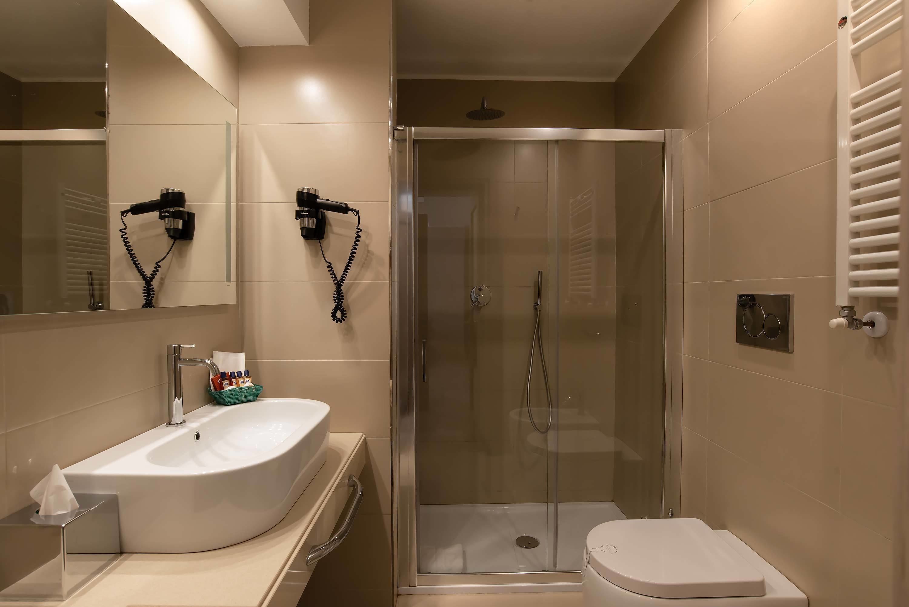 Une salle de bain moderne avec un grand lavabo blanc, une douche à parois de verre et des toilettes.