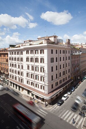 Un edificio de varios pisos con un estilo arquitectónico clásico, que presenta una fachada simétrica y una entrada central.