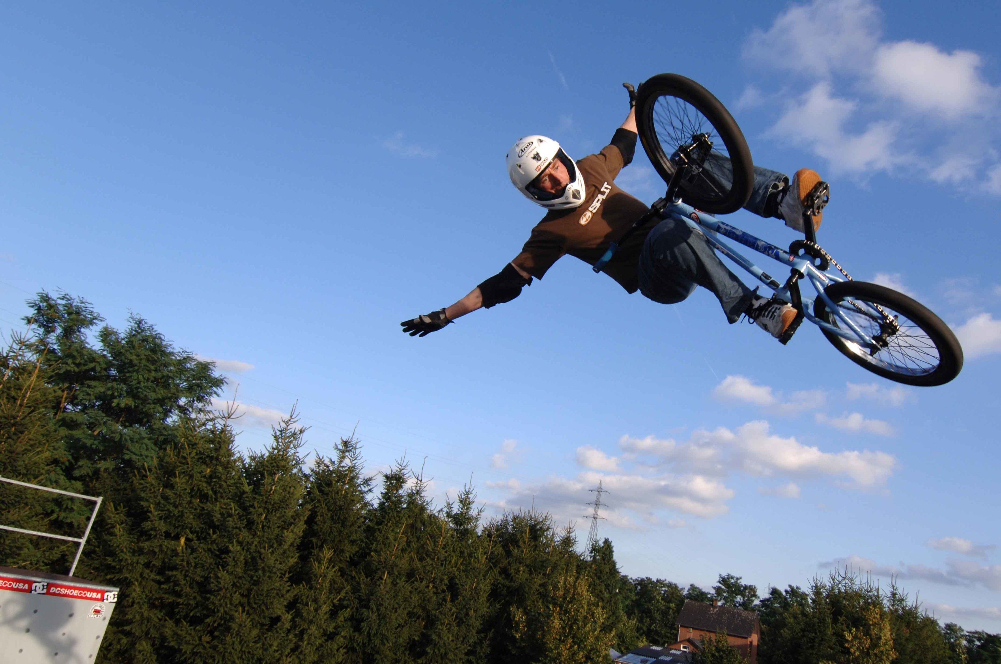 A person performing a BMX stunt in mid-air.