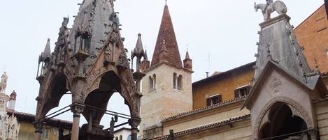 Un edificio histórico con arquitectura gótica ornamentada, que incluye arcos apuntados y estatuas.