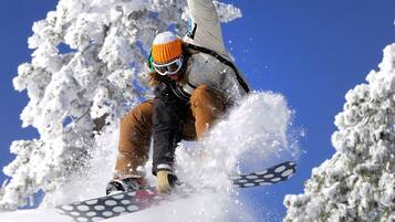 A snowboarder performing a jump with snow flying around.