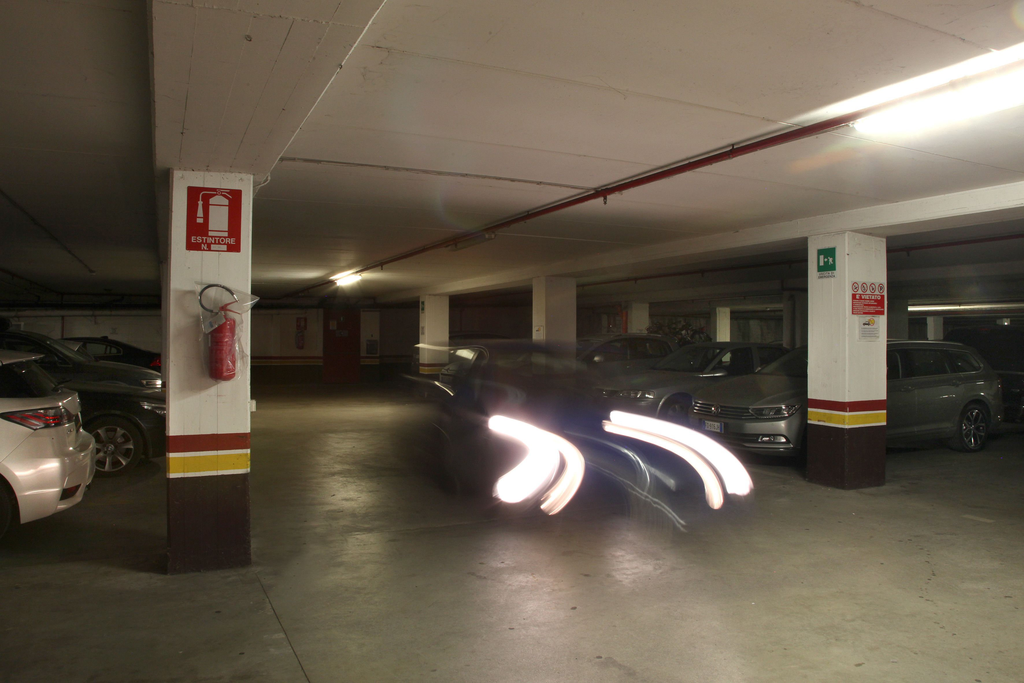 Een parkeergarage met meerdere verdiepingen, waar auto's op verschillende niveaus staan.