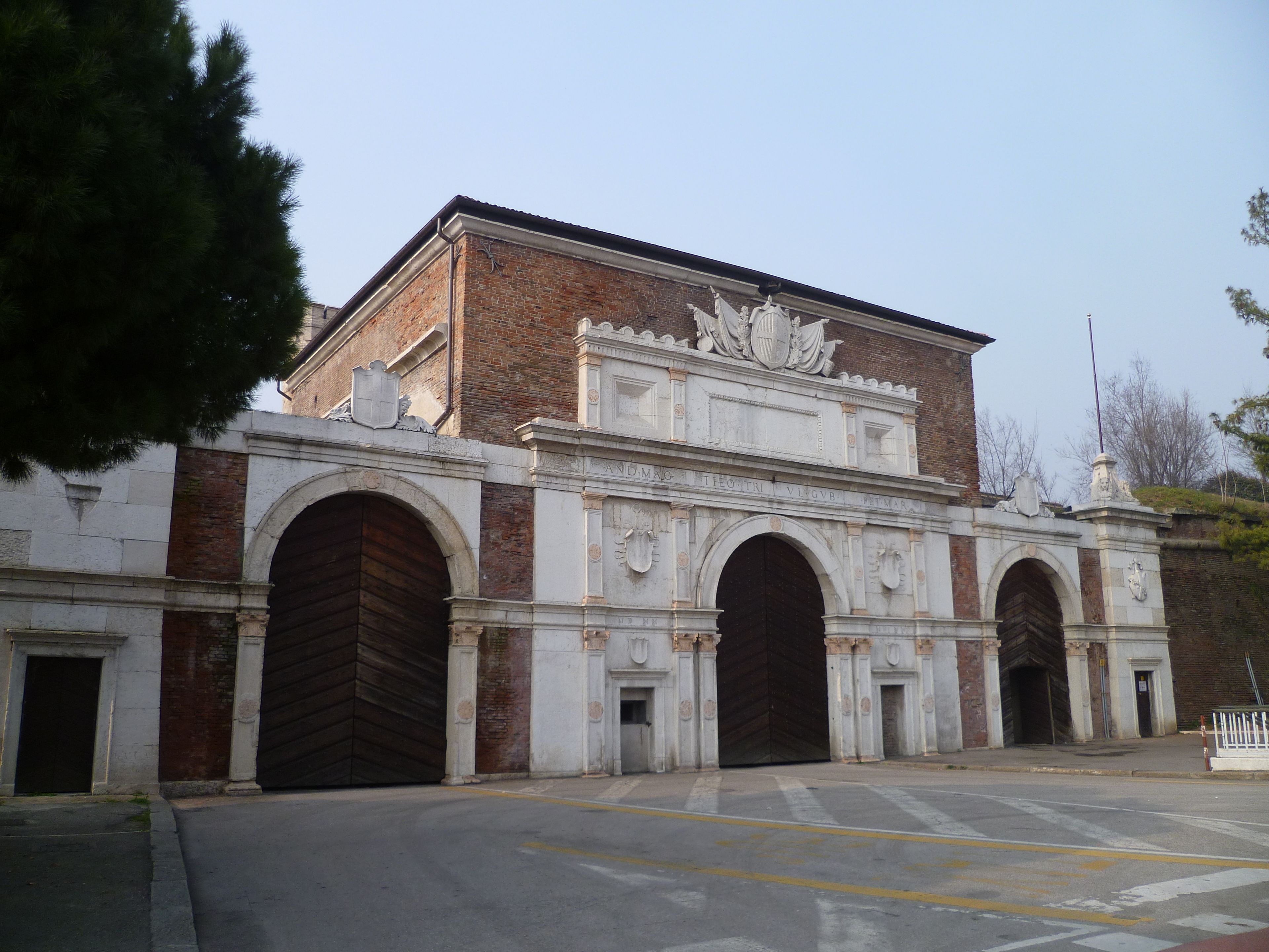 A historic building with large arched entrances and detailed stonework.