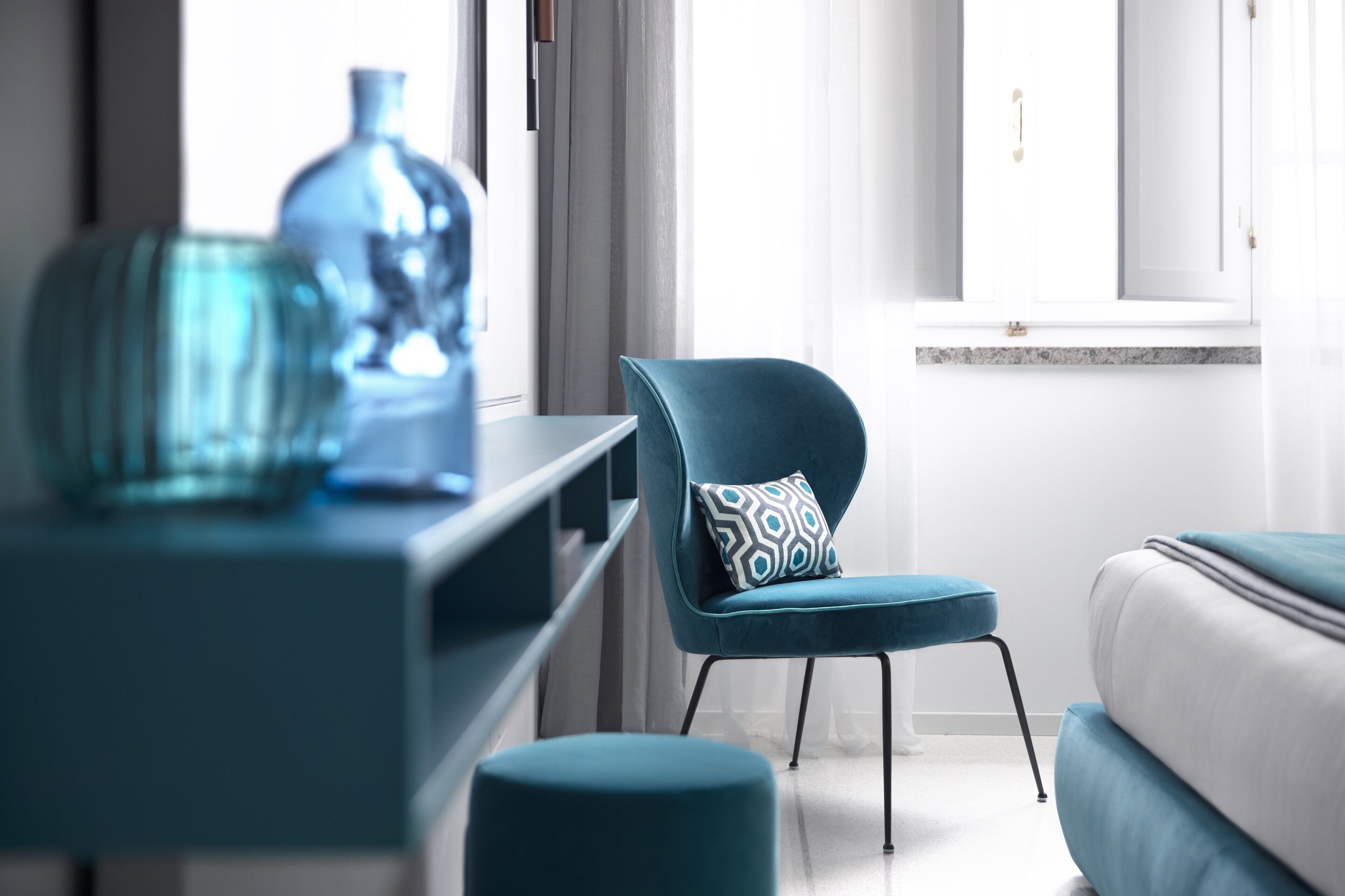 Una sala moderna con un sofá azul, un sillón azul a juego y una mesa de centro de vidrio.