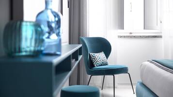 Una sala moderna con un sofá azul, un sillón azul a juego y una mesa de centro de vidrio.