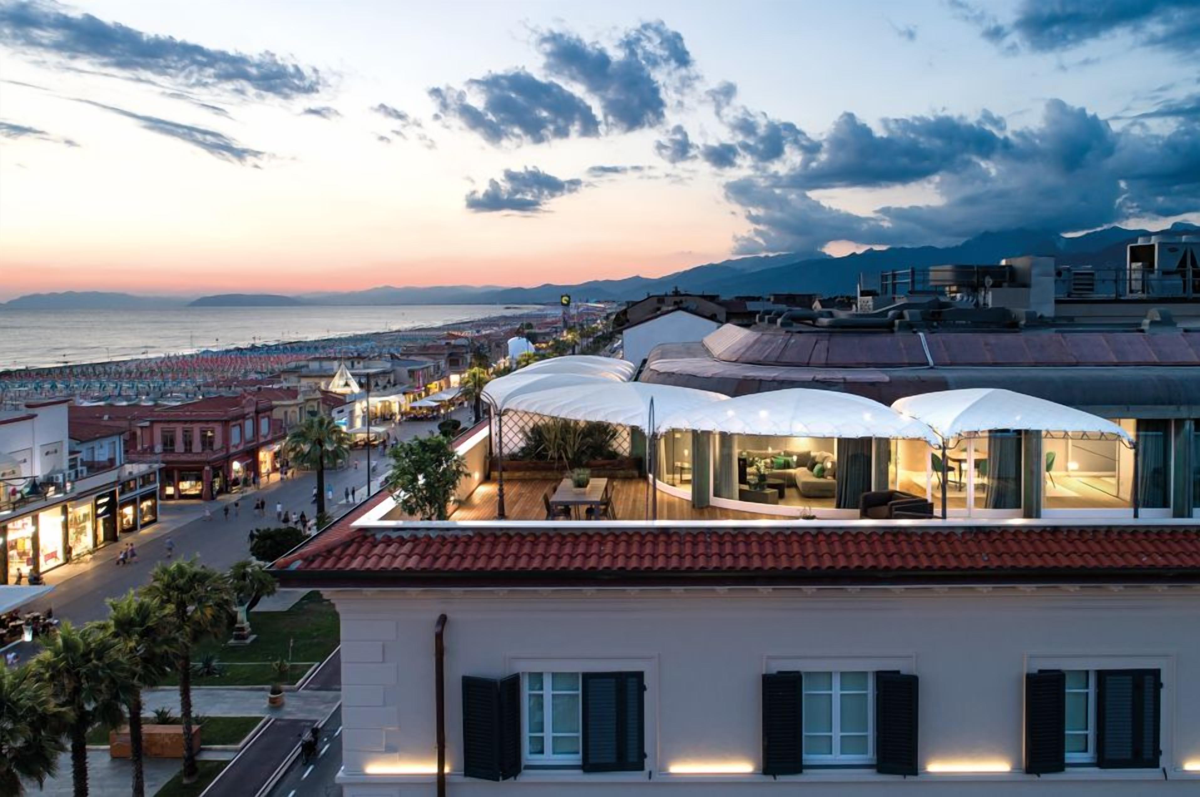 Un hôtel doté d’une terrasse offrant une vue sur la plage et le paysage urbain.