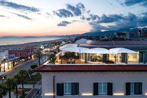 Un hotel con terraza con vistas a la playa y al paisaje urbano.