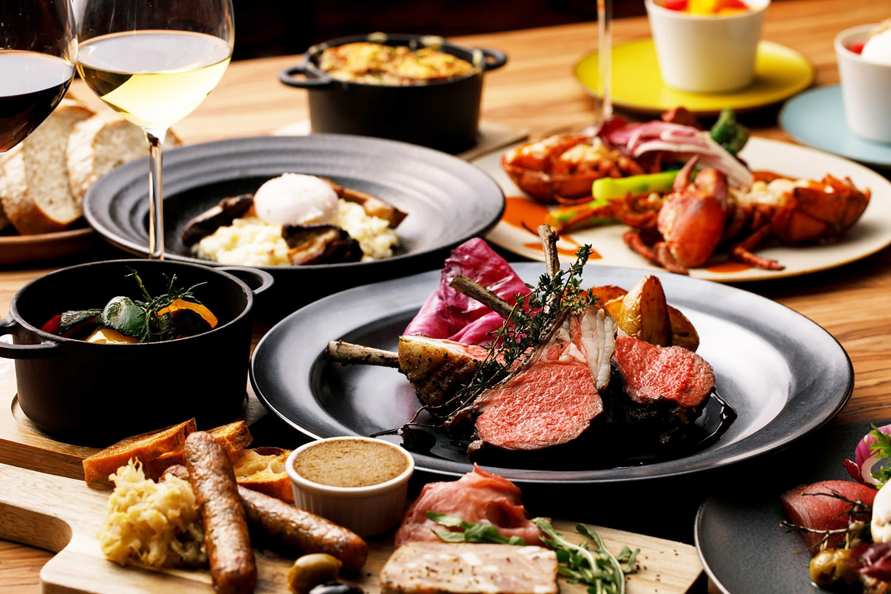 A variety of dishes including seafood, meats, and vegetables on a wooden table.