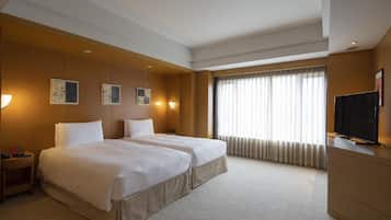 Une chambre d’hôtel avec deux lits, une télévision et des œuvres d’art accrochées au mur.