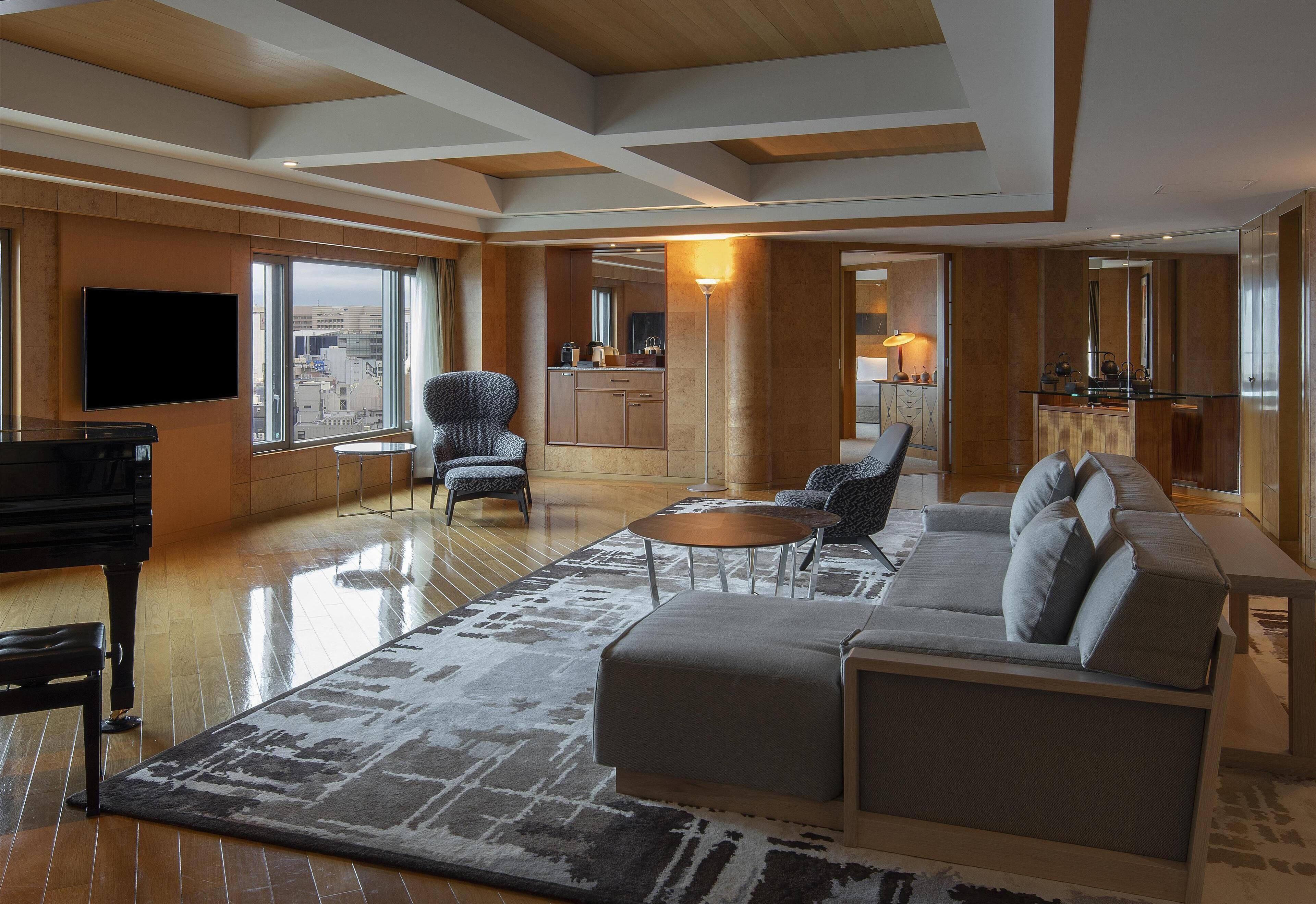 A spacious living room with a grand piano, a sofa, and a coffee table.